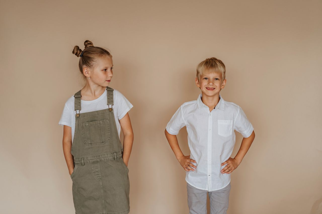 Mastering the First Impression: Your intriguing post title goes here A smiling brother and sister in casual clothing pose against a neutral background.