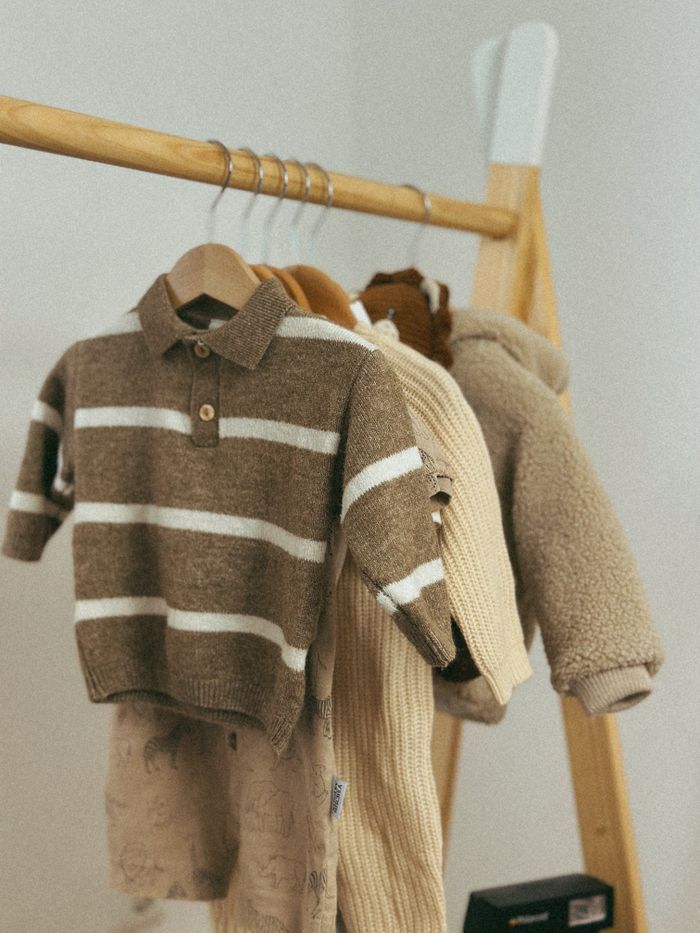 The Art of Drawing Readers In: Your attractive post title goes here Warm childrens sweaters displayed on a wooden rack, perfect for autumn fashion.