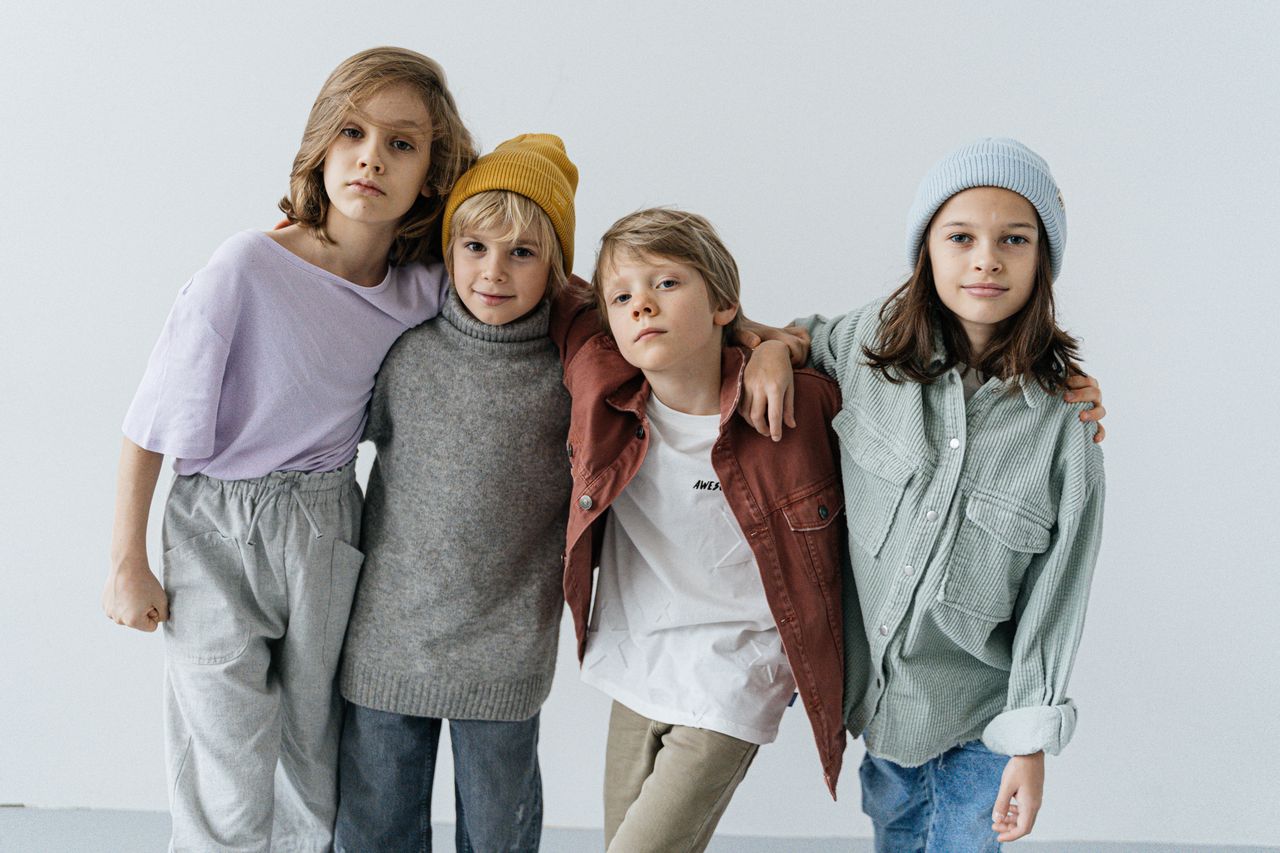 journey Group of fashionable kids posing in a studio setting wearing trendy outfits.